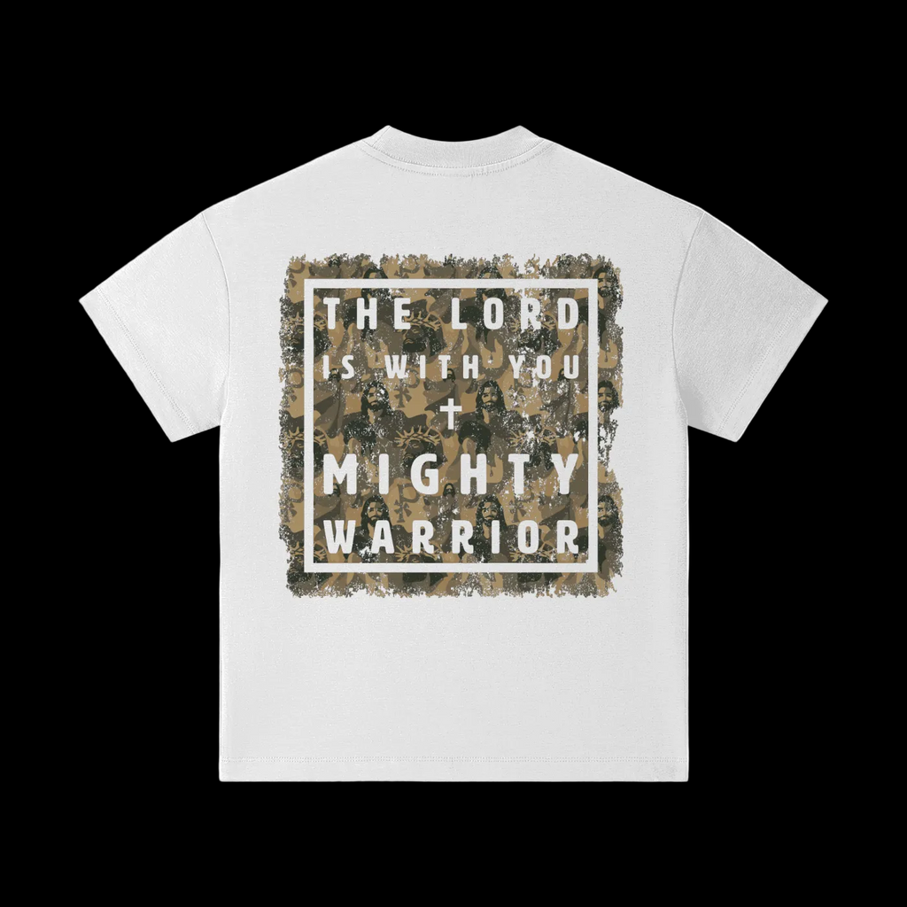 A white short-sleeve t-shirt shown from the back, featuring a large square graphic print with a distressed camouflage border and the text 'THE LORD IS WITH YOU + MIGHTY WARRIOR' over a tan and brown camo background.
